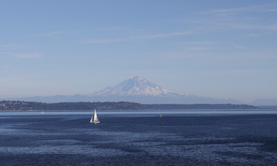 sailboat on ocean with mt rainier