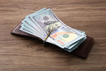 100 US Dollar bills stack on wooden table