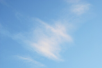 Moving cloud illuminated by  evening light in blue sky atmosphere. Abstract nature blurred background.