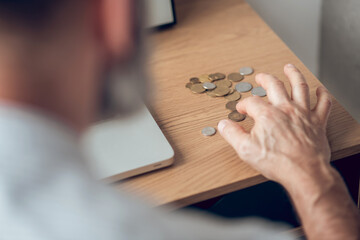 Close up picture of a man calculating coins on the table
