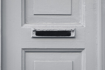 ein Briefkasten ohne Klappe in einer weißen Holztür