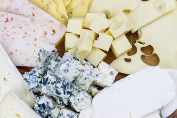 Different kinds of cheese on a cutting board. Close-up