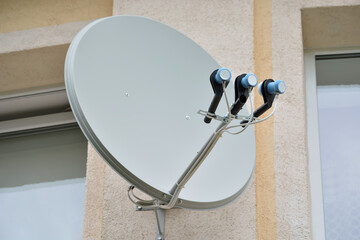 Satellite dish on the wall of a residential building.