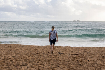 Female watching the waves on a sandy. beach