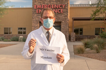 Angry doctor in white coat and mask holds injection and no vaccine mandate sign