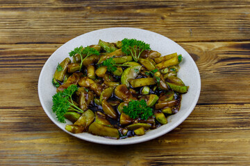 Tasty marrows in soy sauce on wooden table