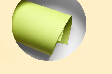 Composition with rolled paper sheet on color background