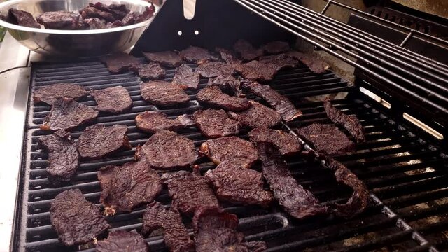 Home cooking - Placing almost ready beef jerky back on smoker from dehydrator for further flavor enhancement.