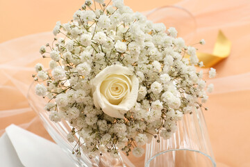 Beautiful wedding bouquet and glasses on color background, closeup