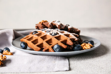 Plate of delicious Chocolate Belgian Waffles with blueberry and walnut on table