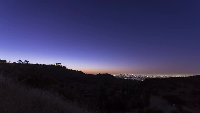 A timelapse of sunrise over the Griffith Park Observatory looking onto Downtown Los Angeles in the background.