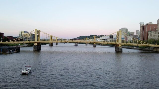 Aerial drone view low towards bridges on the Allegheny river, colorful evening in Pittsburgh, USA