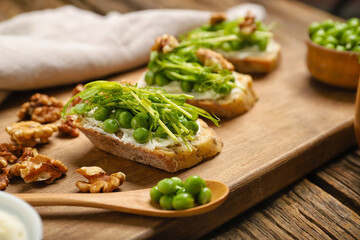 Board with tasty vegetarian bruschettas on wooden background, closeup