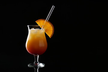 Glass of tasty Tequila Sunrise cocktail on dark background