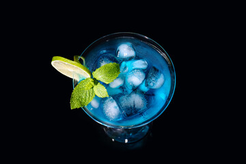 Glass of Blue Lagoon cocktail on dark background