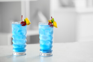 Glasses of Blue Lagoon cocktail on table in room