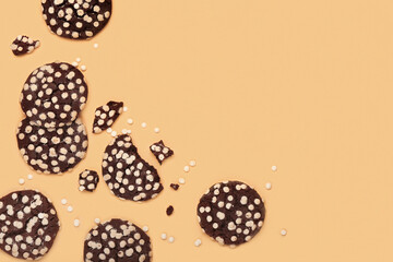 Broken tasty cookies with white chocolate chips on color background