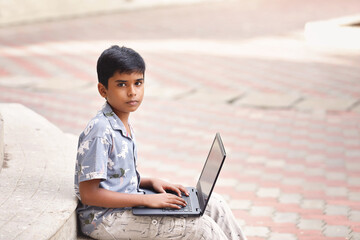 Portrait of Indian little boy using Laptop for online class	
