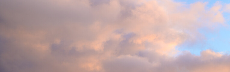 Naklejka na ściany i meble Fluffy ethereal pastel clouds lighted by the fading sun, as a nature background 