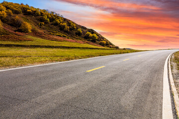 Asphalt road and mountain nature landscape at sunset.Road and mountain scenery in autumn.