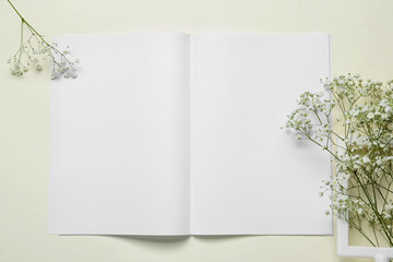 Blank magazine with gypsophila flower on light background