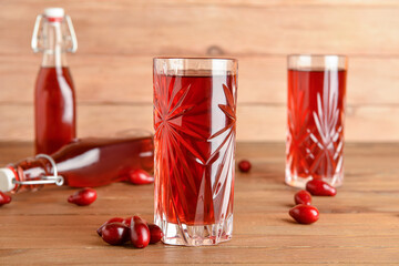 Glass of healthy dogwood berry drink on wooden background © Pixel-Shot