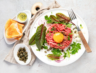Beef steak tartare on light background. French cuisine concept.