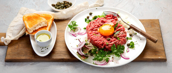 Beef steak tartare on light background. French cuisine concept.