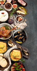 French food assortment on dark background.