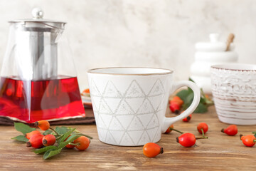 Cup of rose hip tea and berries on table