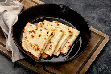 Crepes with sweet toppings on dark background.