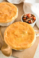 Wooden board tasty vegetable pot pies on white background