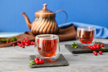 Glasses of tasty lingonberry tea on table