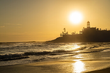 Fototapeta premium Golden hour on the beach, summer sunset in Los Cerritos Beach, with the silhouette of the waves and the mountain near the beach, La Paz Baja California Sur, Todos Santos. Mexico