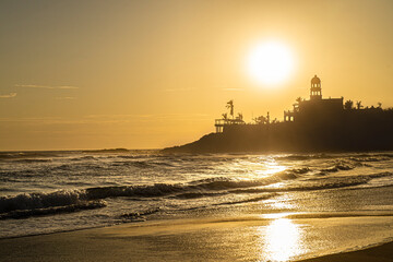 Golden hour on the beach, summer sunset in Los Cerritos Beach, with the silhouette of the waves and...
