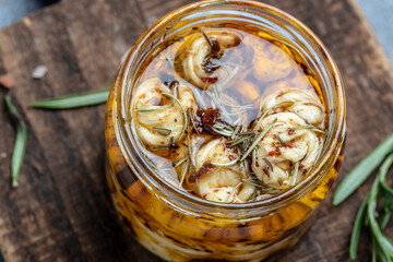 Marinated cheese with olive oil and rosemary in glass jar on wooden board. Ecology and eco-products. banner, menu, recipe, top view
