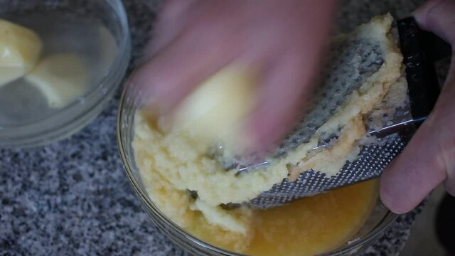 Closeup of Cooking otato pancakes draniki on grater . High quality FullHD footage