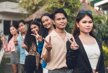 A group of six young and dynamic friends from late teens to early 20s, in a single file making a...