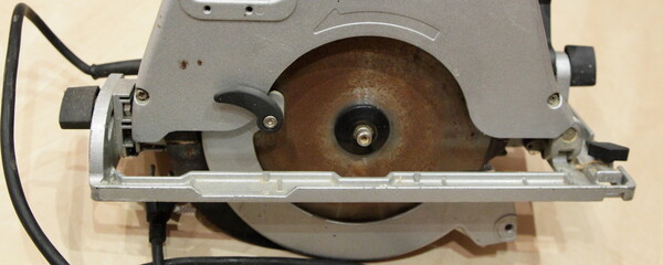 Used circular saw with rusty sawindg disc closeup side view - DIY manual electrical power tools