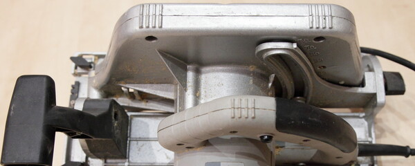 Used circular saw with handles closeup top view - DIY manual electrical power tools