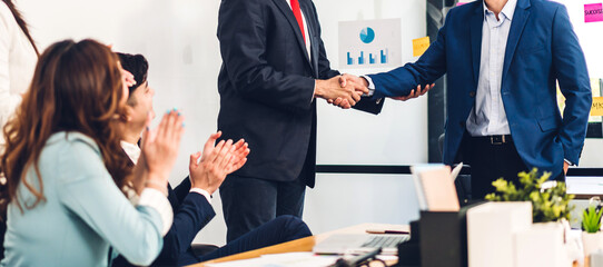Image two asian business partners successful handshake together in front of group teamwork casual business clapping hands winning success agreement in modern office.Partnership approval and teamwork