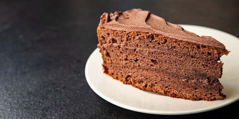 piece of chocolate cake cocoa sponge cake, chocolate ganache, brown cream sweet dessert ready to eat meal snack on the table copy space food background rustic. top view