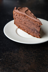 piece of chocolate cake cocoa sponge cake, chocolate ganache, brown cream sweet dessert ready to eat meal snack on the table copy space food background rustic. top view