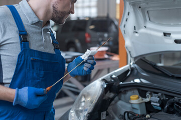 Mechanic checking a car's oil level in the garage
