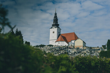 Fototapeta premium Church of holy trinity above the village of Rogaska Slatina in Slovenia, rising high above the graveyard nearby.