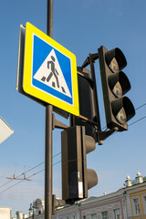 On blue sky background traffic light and pedestrian crossing sign