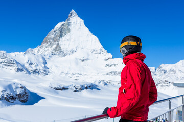 Skier enjoying the Alpine view. Snow mountain range with Matterhorn on the background. Zermatt Alps...