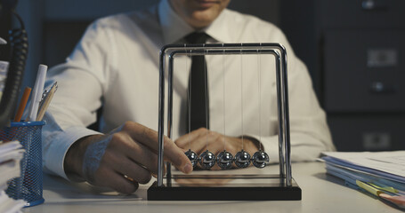 Bored office worker and Newton's cradle