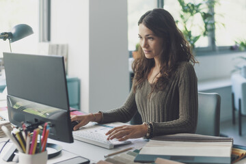 Designer working with her computer in her studio