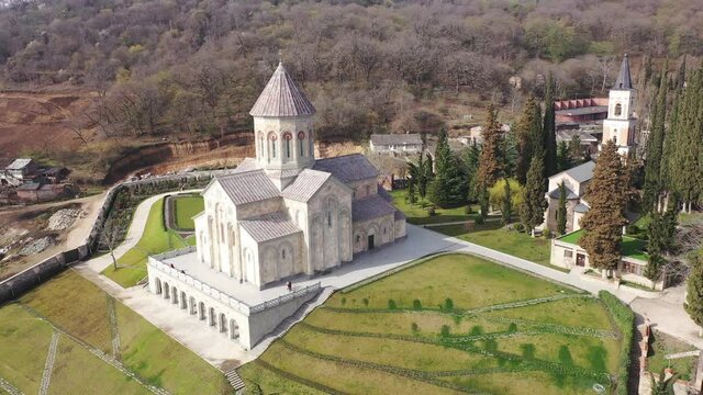 Scenic spring aerial view of Church of St. Nino in monastic complex of Bodbe nunnery on hillside overlooking Alazani Valley and Greater Caucasus mountains in background, Sighnaghi, Kakheti, Georgia